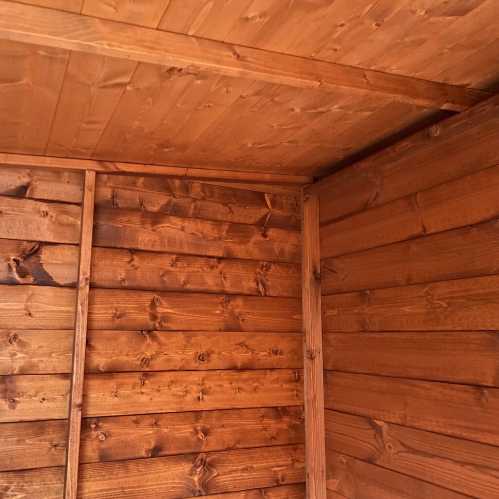 Interior view of a Tiger Pent Bike Shed showing wooden walls and ceiling