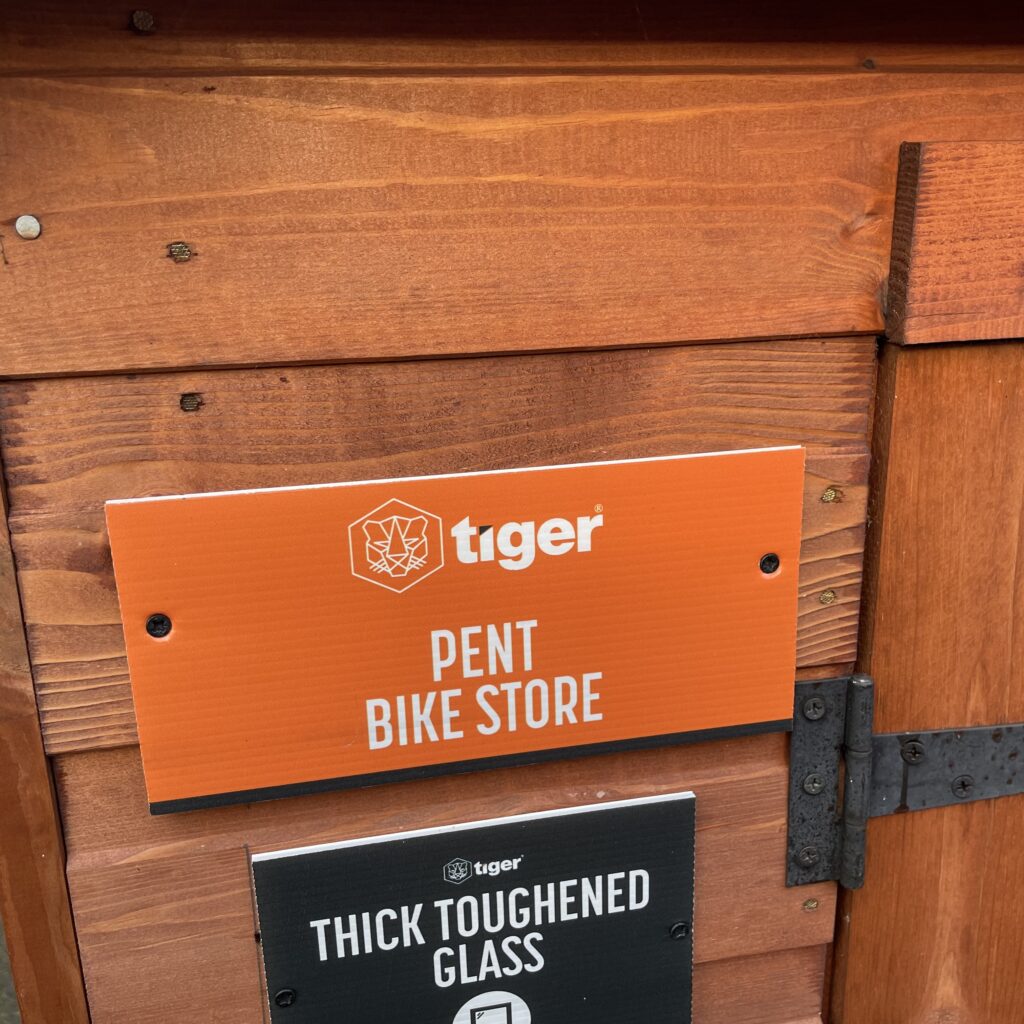 Sign for the Tiger Pent Bike Store showcasing its name and features