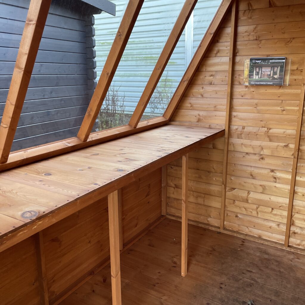 Interior of Tiger Potting Shed featuring a wooden bench and angled windows