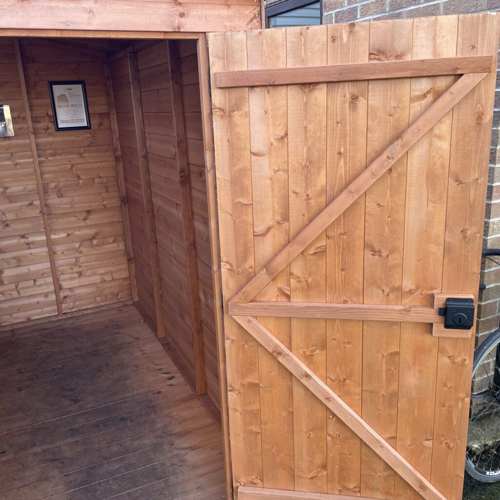 Interior view of the Tiger Potting Shed with wooden door and wall cladding