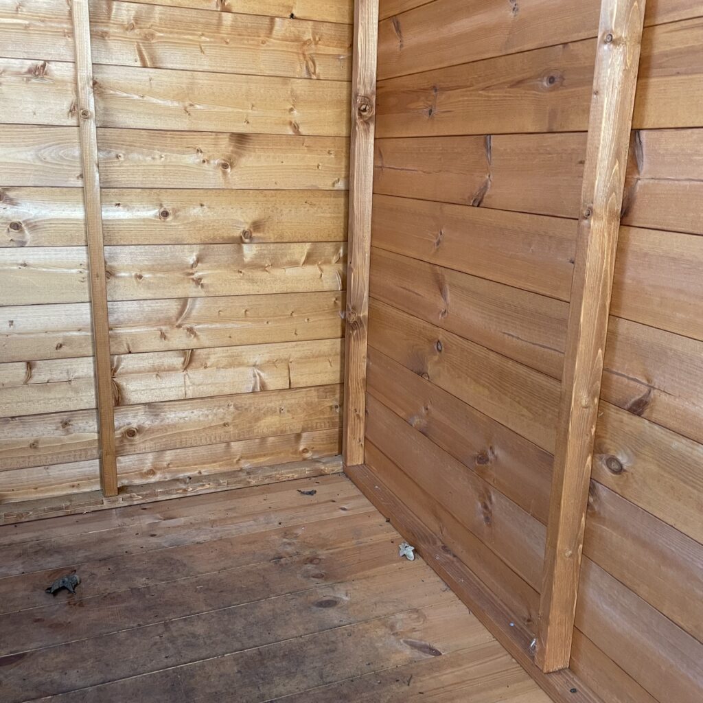 Interior view of the Tiger Potting Shed with wooden walls and floor