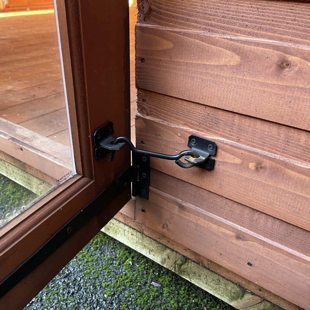 Close-up of a door latch mechanism on a summerhouse