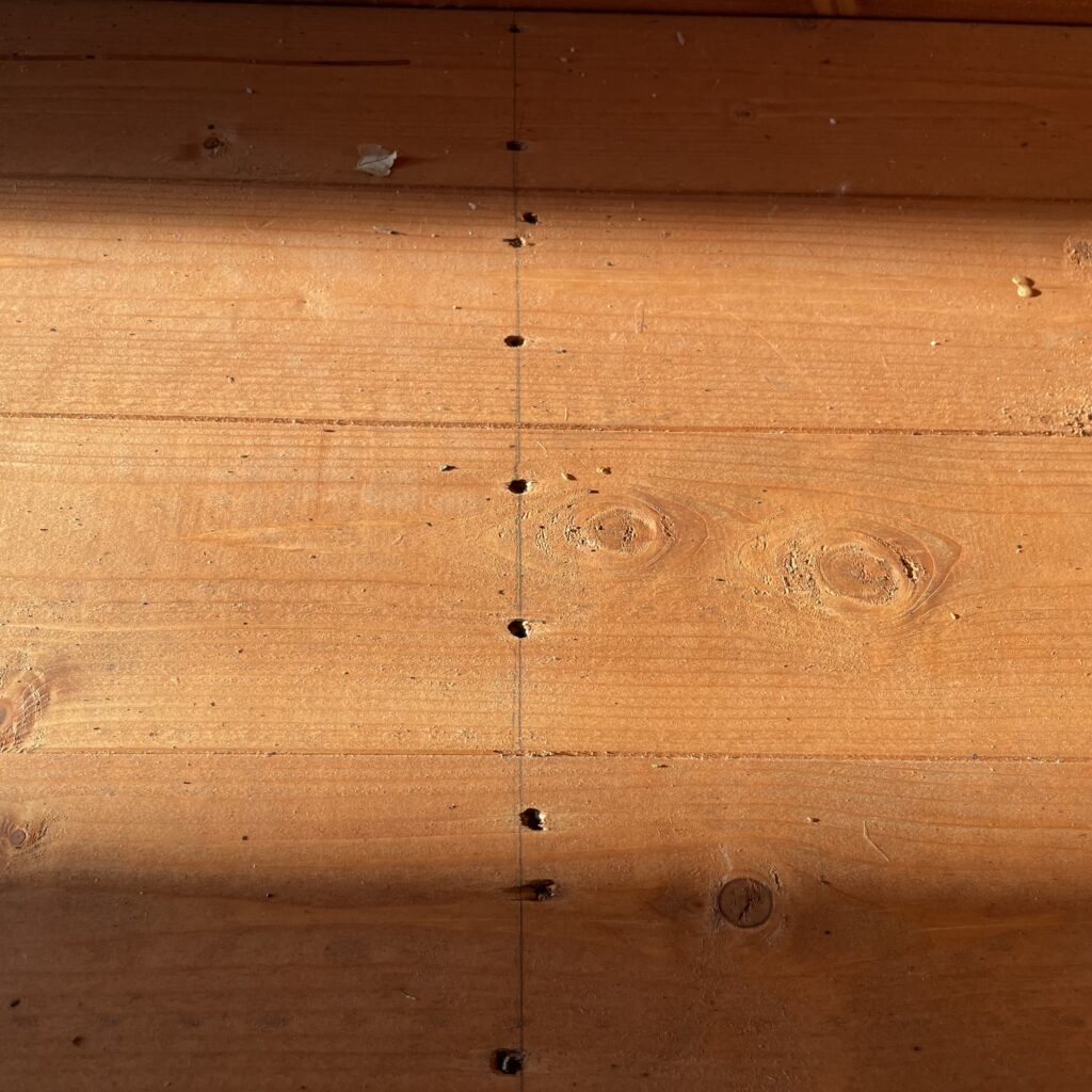 Interior view of wooden floor with visible drill holes