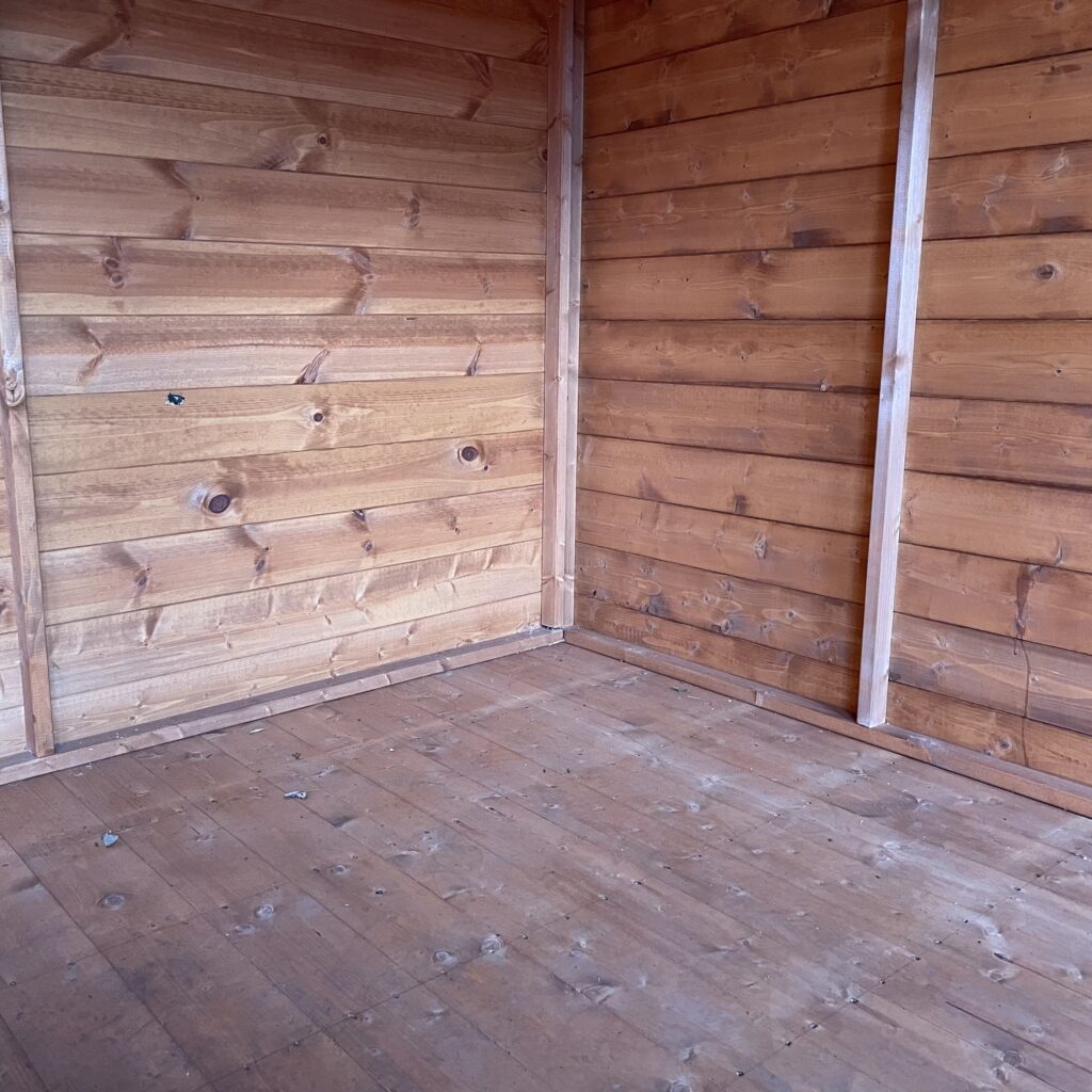 Interior view of the Tiger Retreat Contemporary Summerhouse with wooden walls and flooring