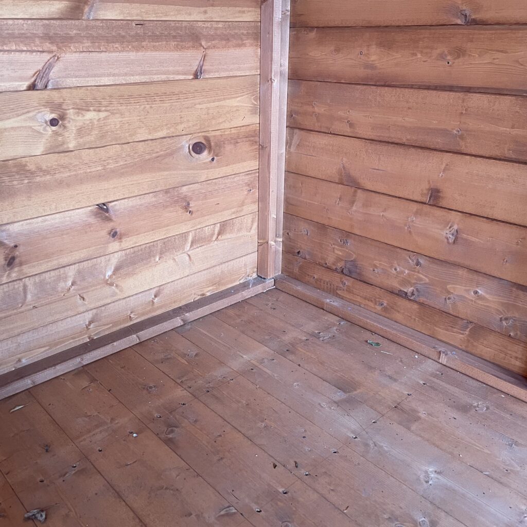 Interior view of the Tiger Retreat Contemporary Summerhouse showcasing wooden walls and flooring