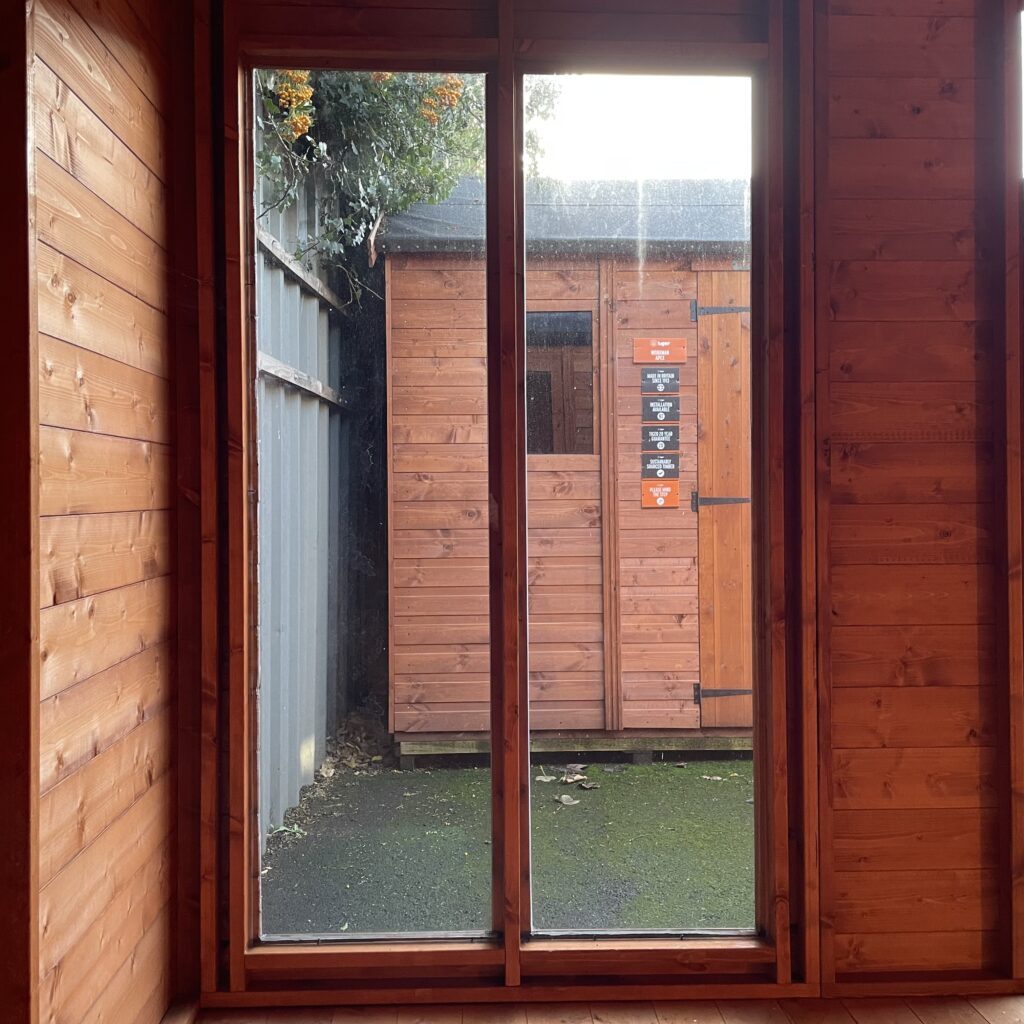 Interior view of the Tiger Retreat Contemporary Summerhouse showcasing large windows