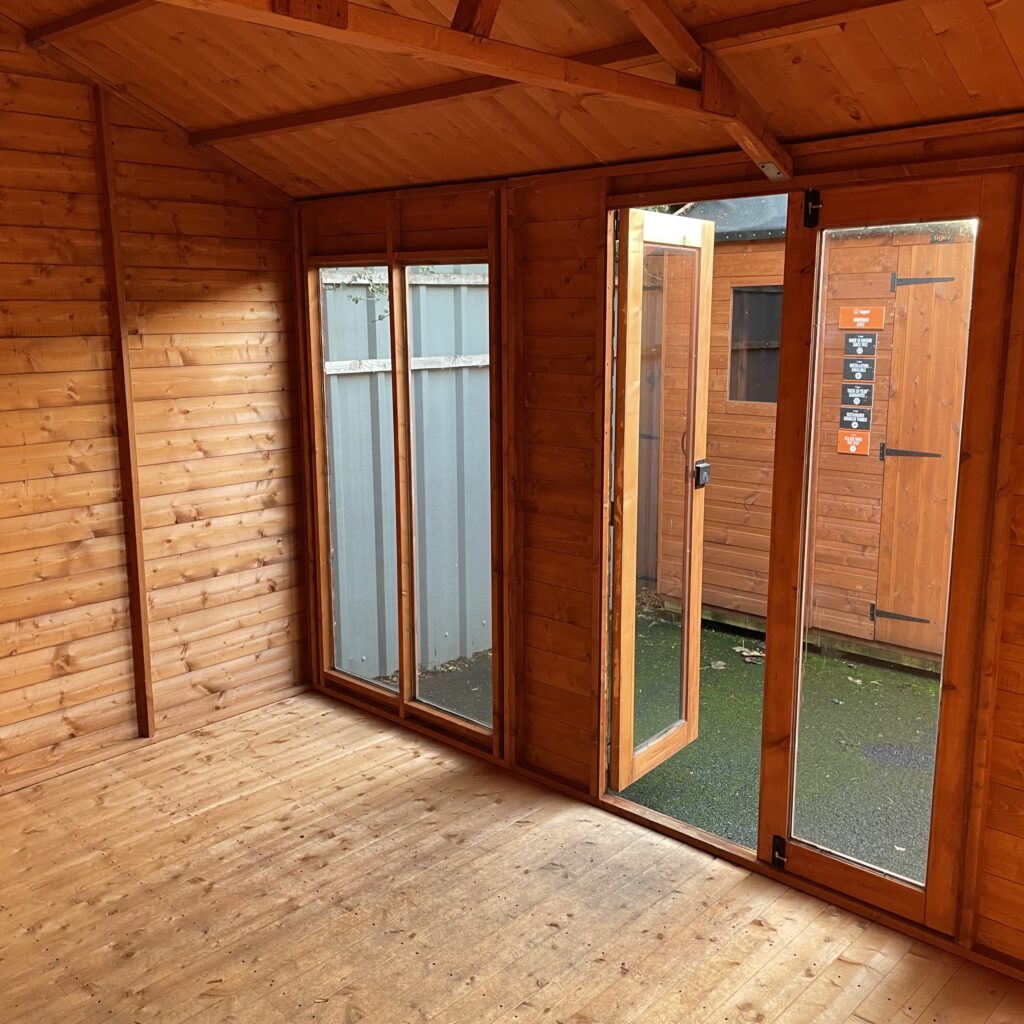 Interior of a Tiger Retreat Contemporary Summerhouse featuring large double doors and wooden walls