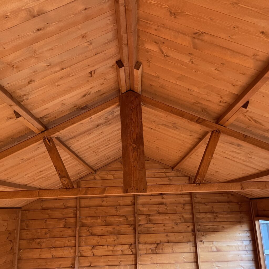 Interior view of the Tiger Retreat Contemporary Summerhouse showing wooden beams and cladding