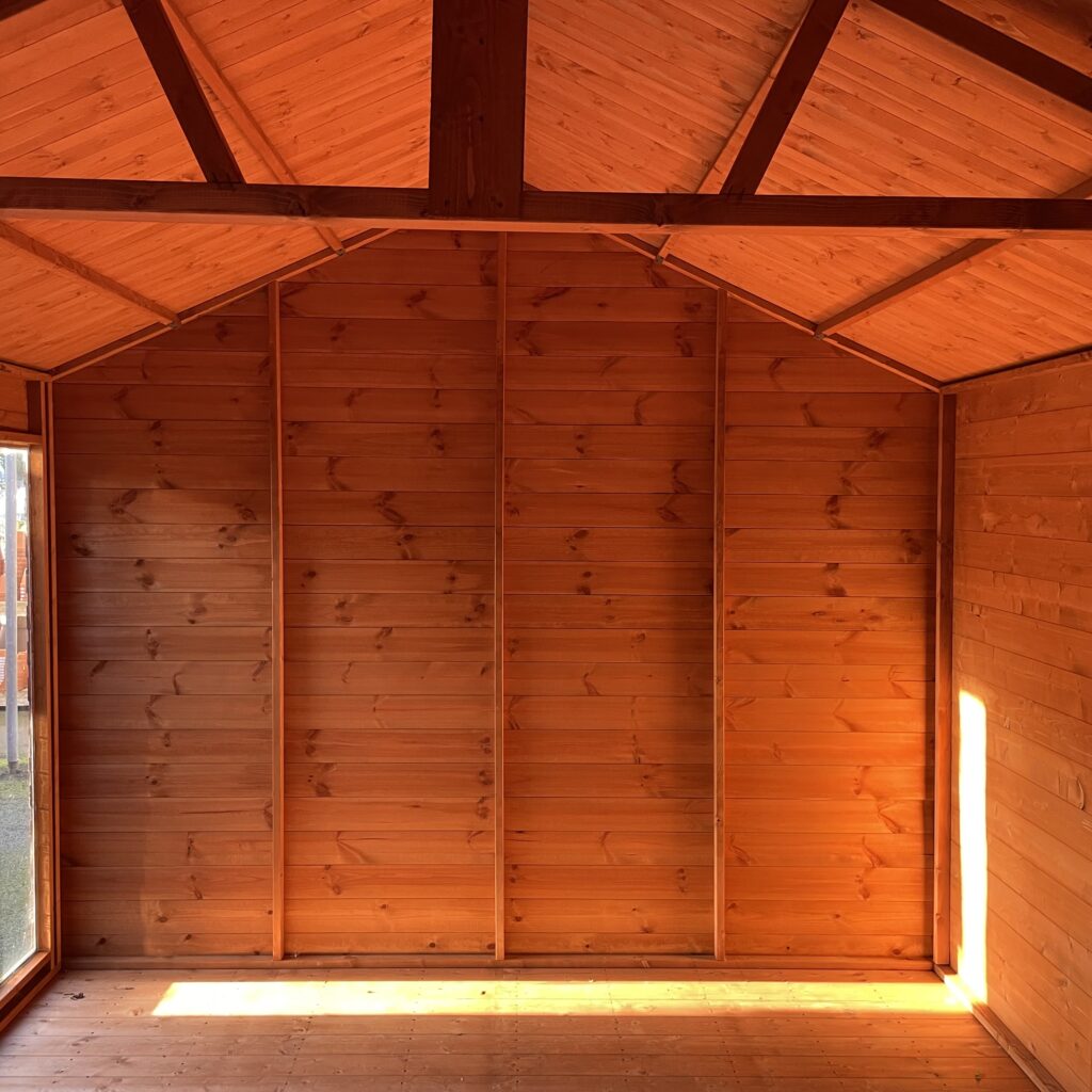 Interior of a Tiger Retreat Contemporary Summerhouse showcasing warm wooden walls and beams
