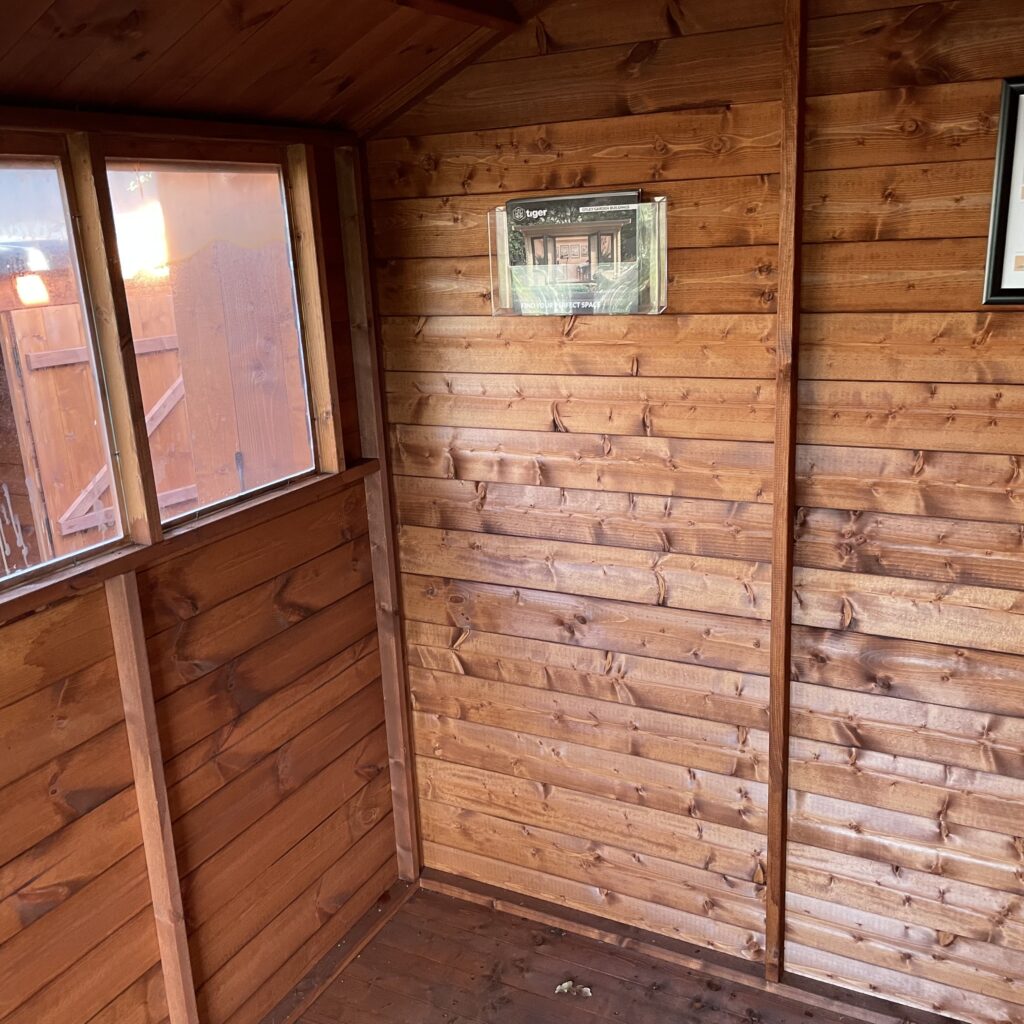 Interior view of the Tiger Shiplap Apex Shed showcasing wooden walls and windows