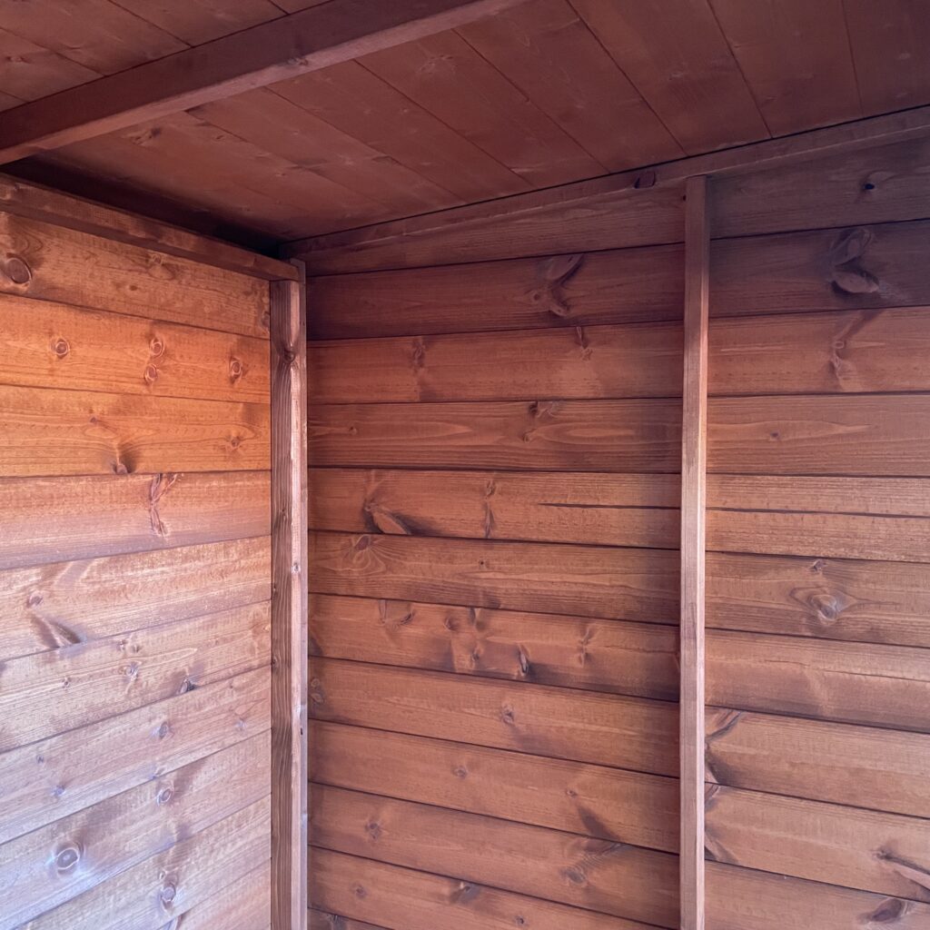 Interior view of the Tiger Shiplap Pent Shed showcasing wooden wall panels