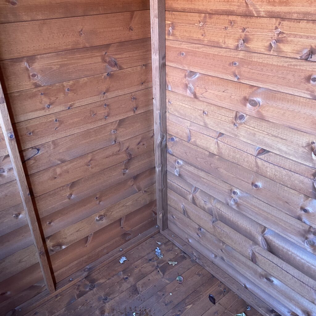 Interior view of a Tiger Shiplap Pent Shed showing wooden walls and floor
