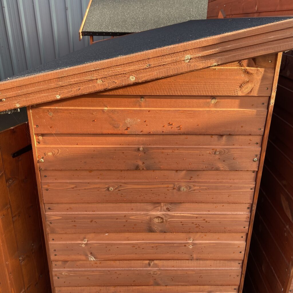 Wooden storage box with an asphalt roof, showcasing the cladding and construction quality