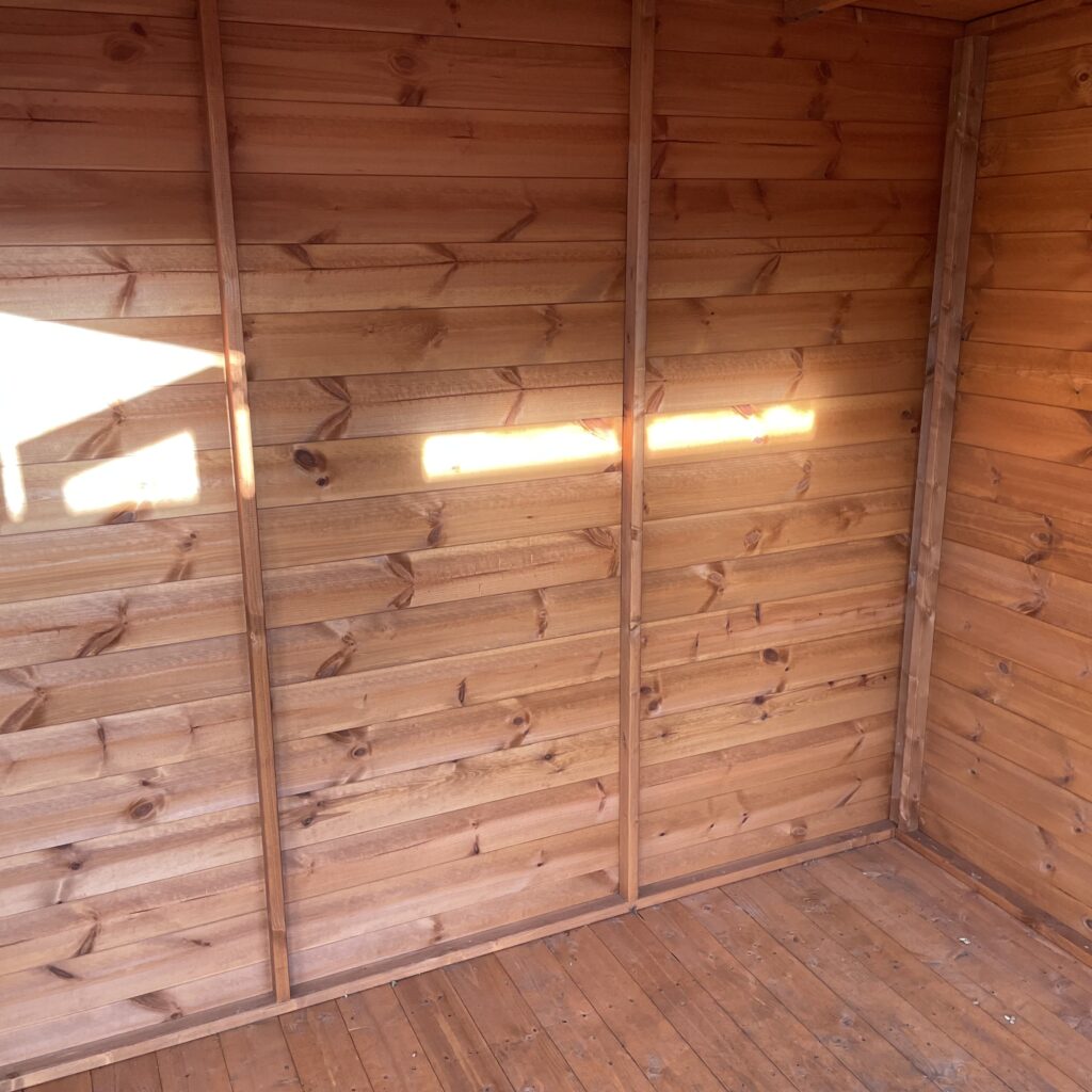 Interior of a timber garden building featuring shiplap cladding