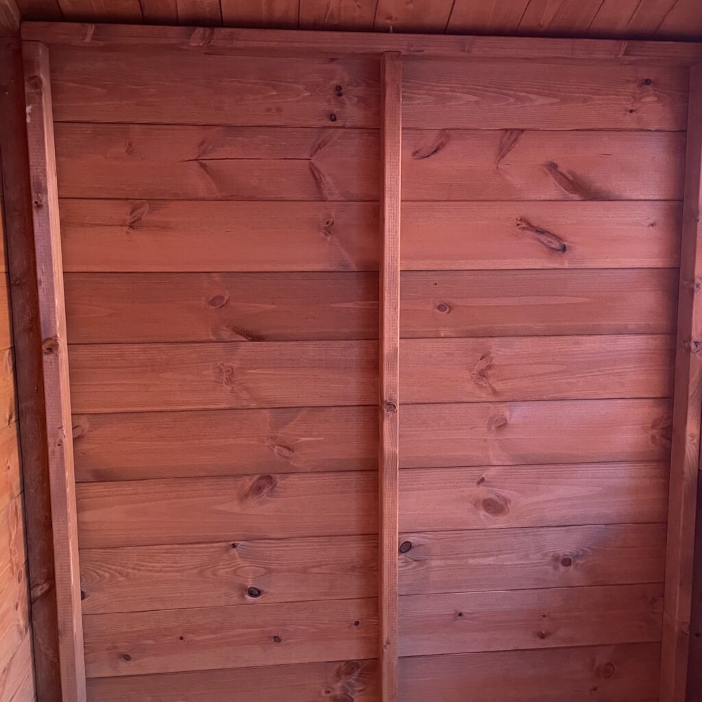Interior timber wall with tongue-and-groove cladding and vertical framing