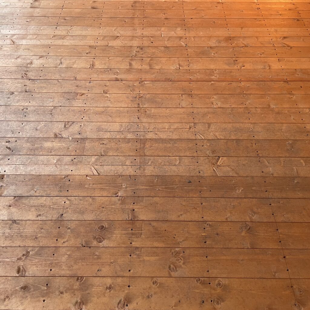 Close-up of wooden floorboards in a garden building