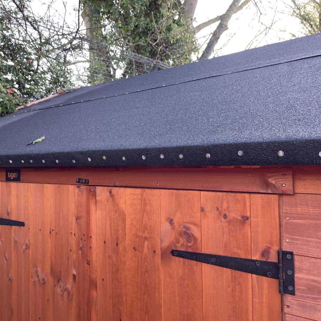 Apex roof of a Tiger shed with felt covering and wooden cladding
