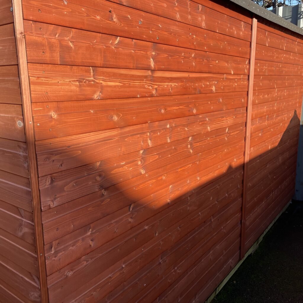 Red cladding of the Tiger Workman Apex Shed showing wood grain texture