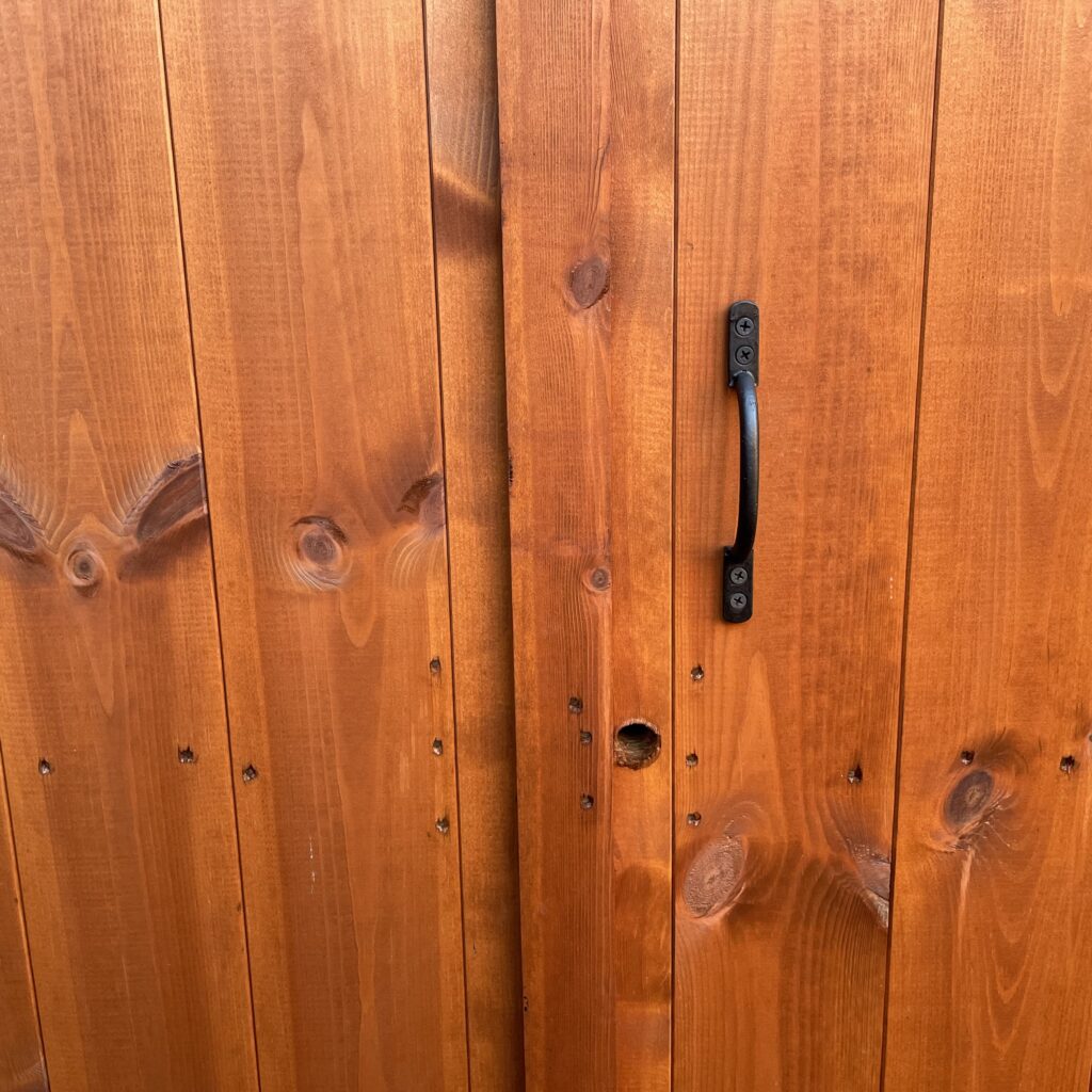 Close-up of the Tiger Workman Apex Shed door showing wood grain and handle