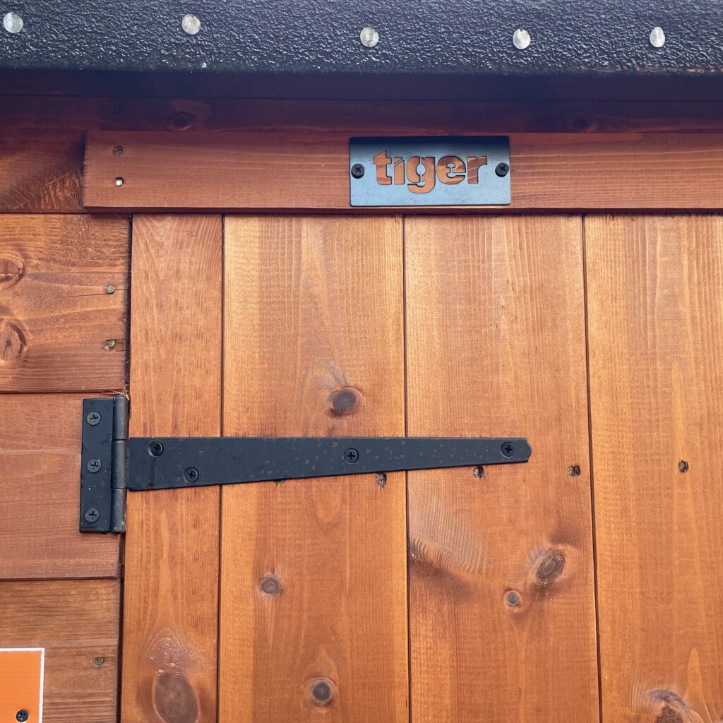 Door of the Tiger Workman Apex Shed featuring a black hinge and handle