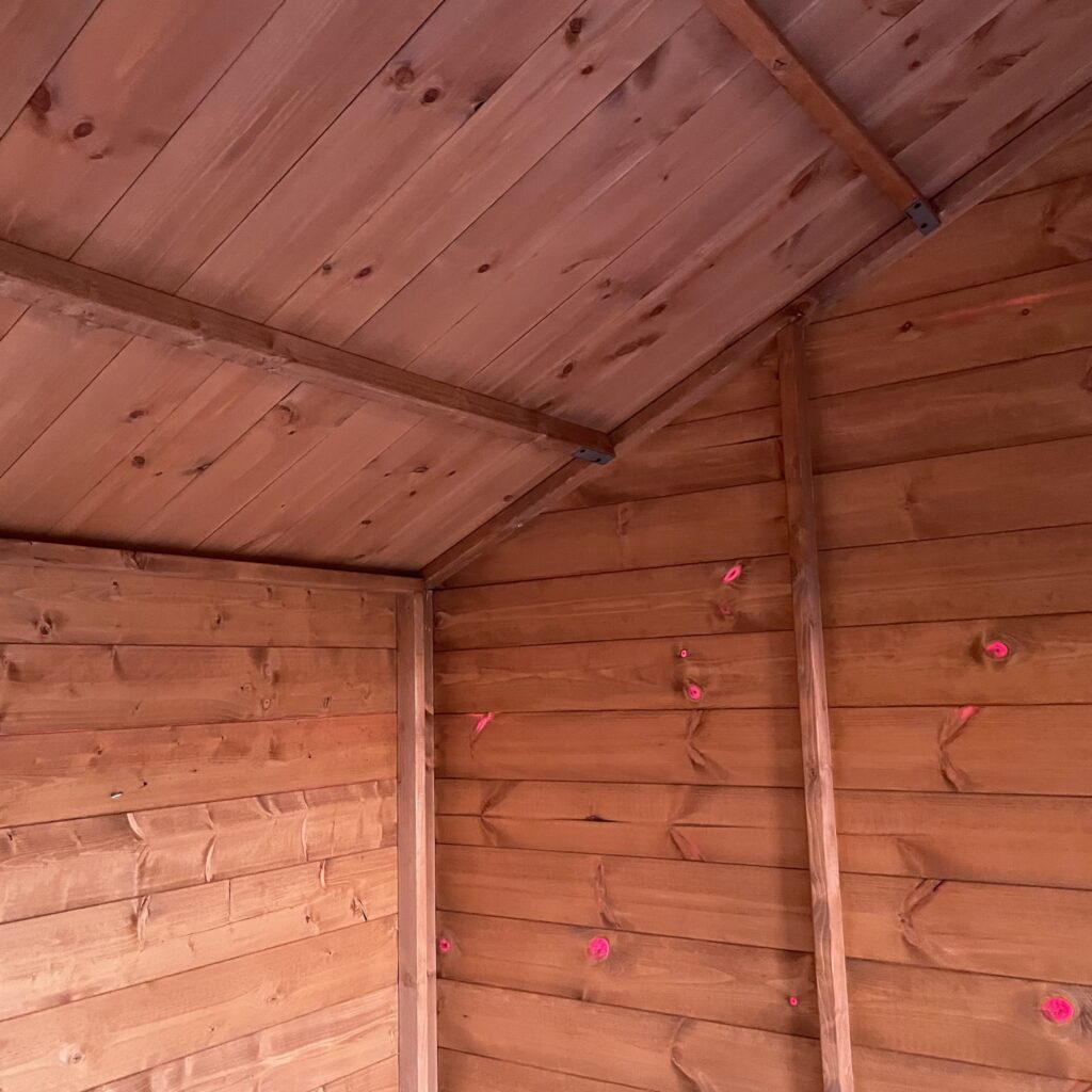 Interior view of a Tiger Workman Apex Shed with wooden walls and ceiling