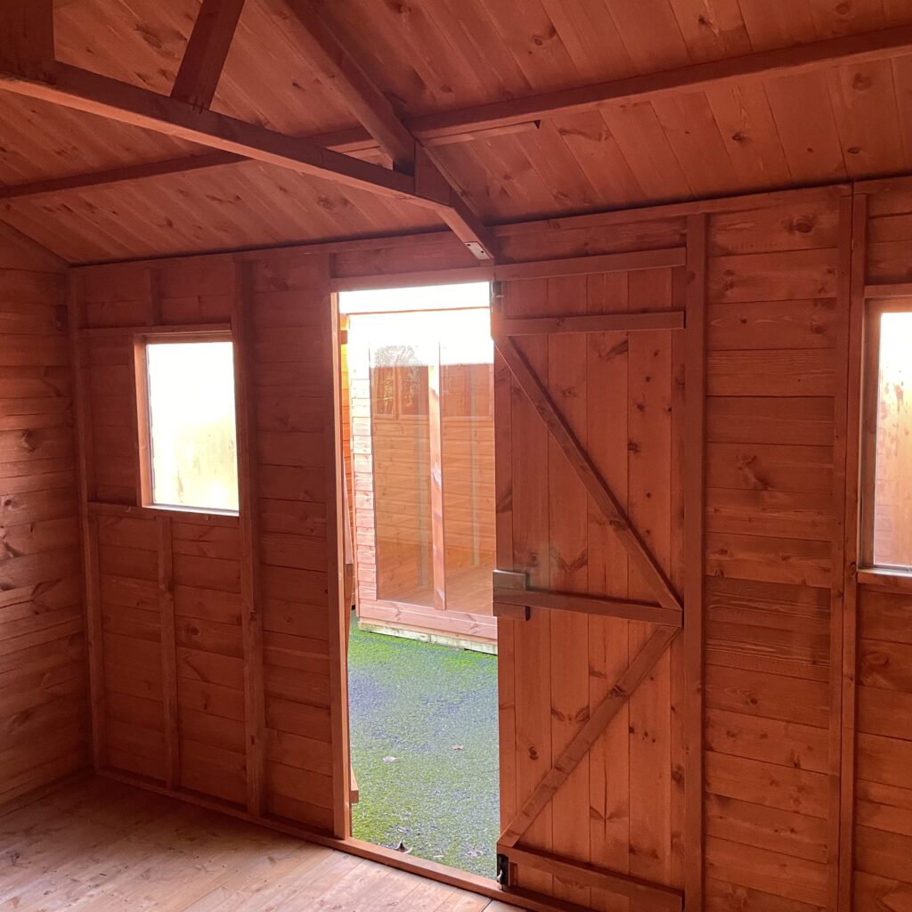 Interior view of the Tiger Workman Apex Shed featuring windows and a door