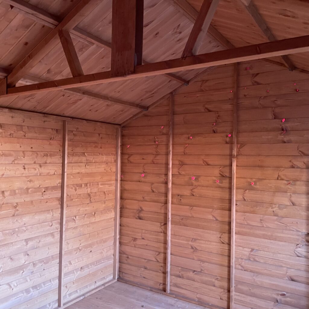 Interior view of a Tiger Workman Apex Shed with wooden walls and apex roof structure