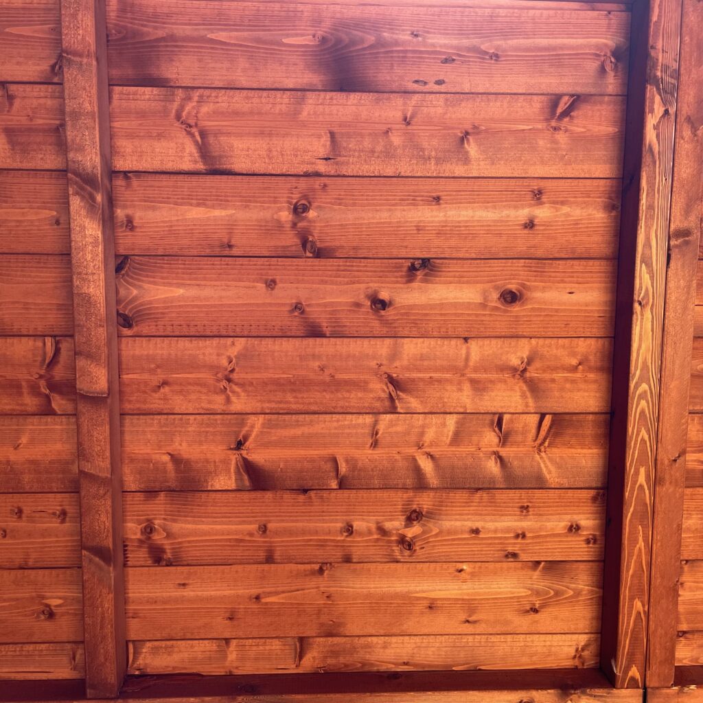 Interior view showcasing the wooden wall panels of a garden building