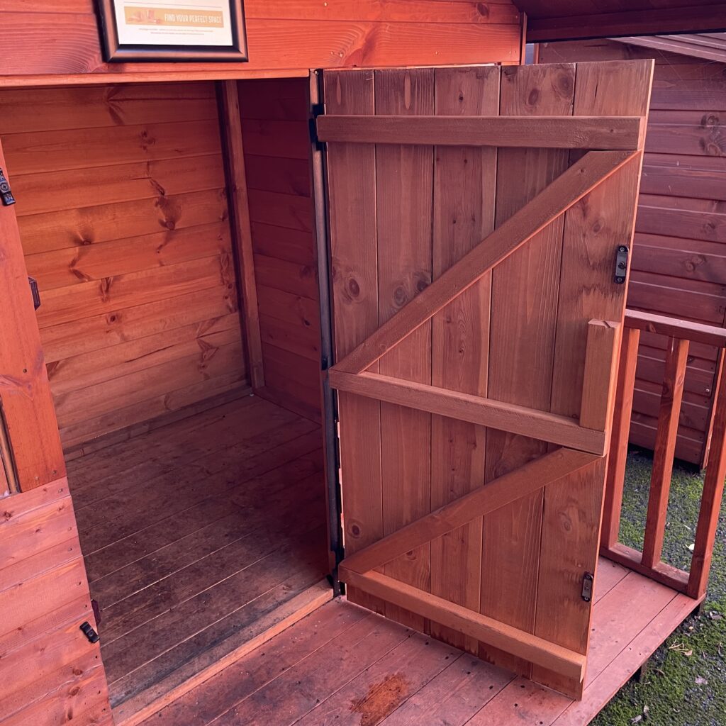 Interior view of the TigerClub Funhouse Playhouse with an open wooden door