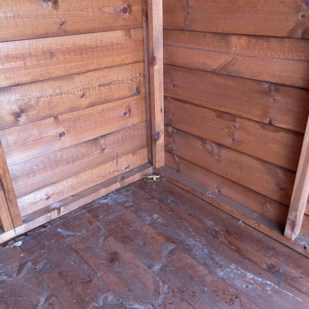 Interior corner of a TigerFlex Apex Bike Shed with wooden panels