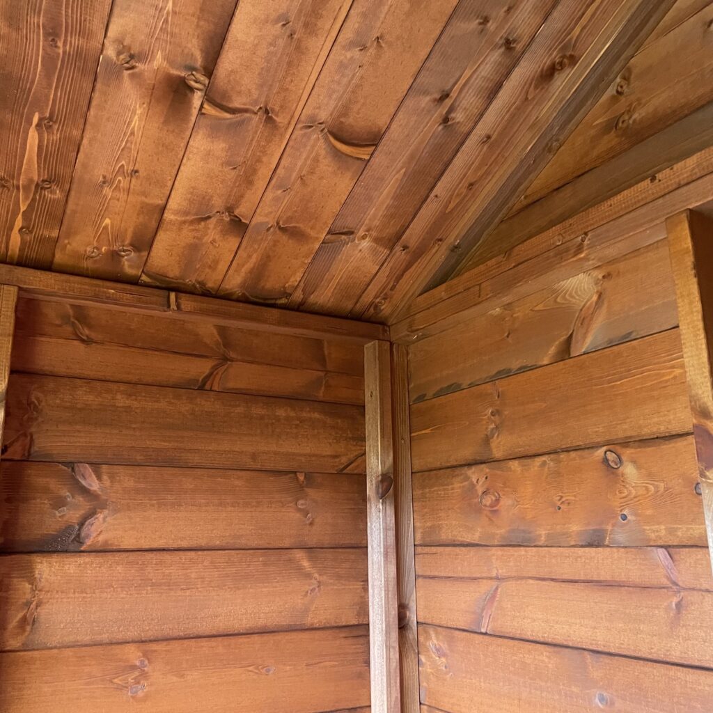 Interior view of a TigerFlex Apex Bike Shed showing wooden walls and apex roof