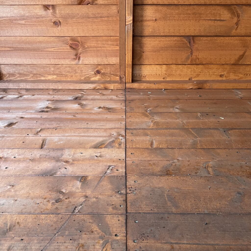 Interior view of a wooden shed floor with visible joinery