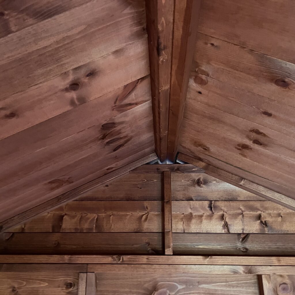 Interior view of apex roof structure showcasing wooden beams and paneling