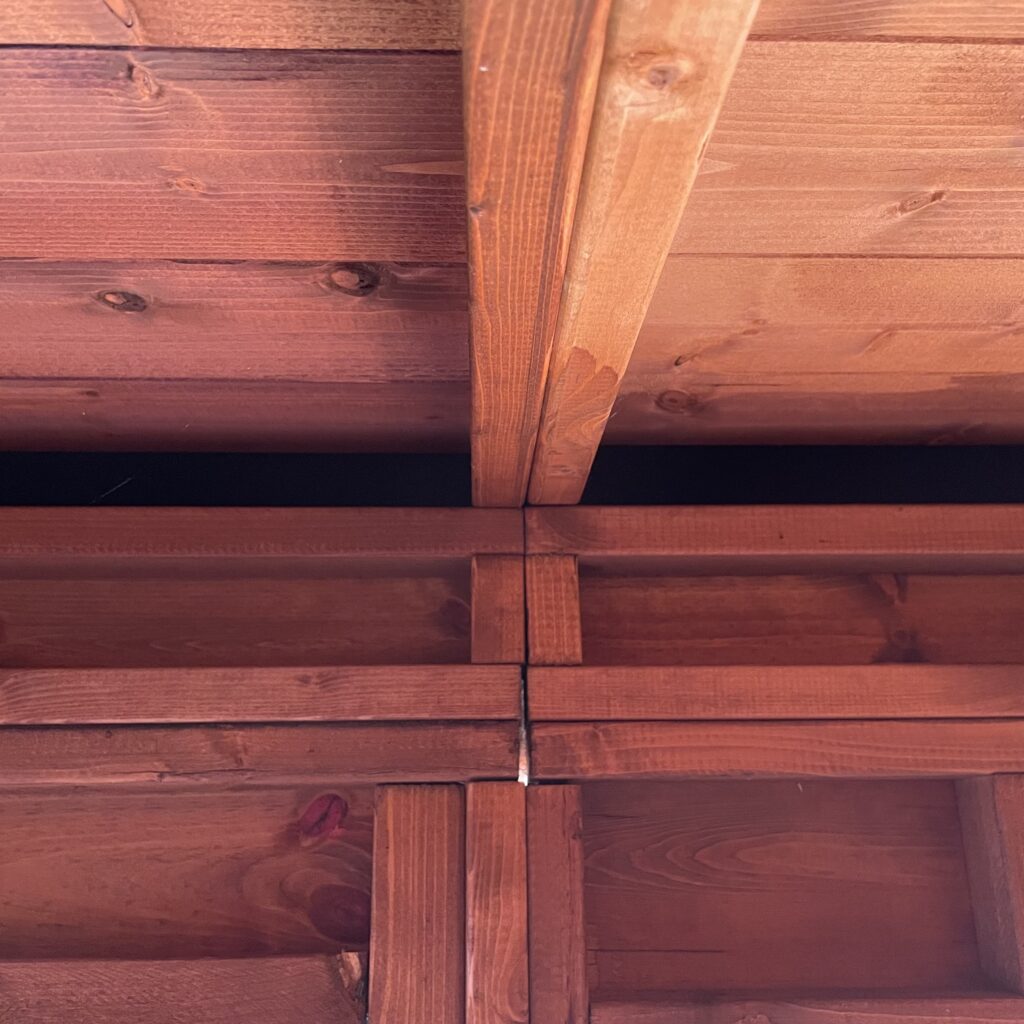 Interior view of the pent roof structure with visible wooden beams and joints