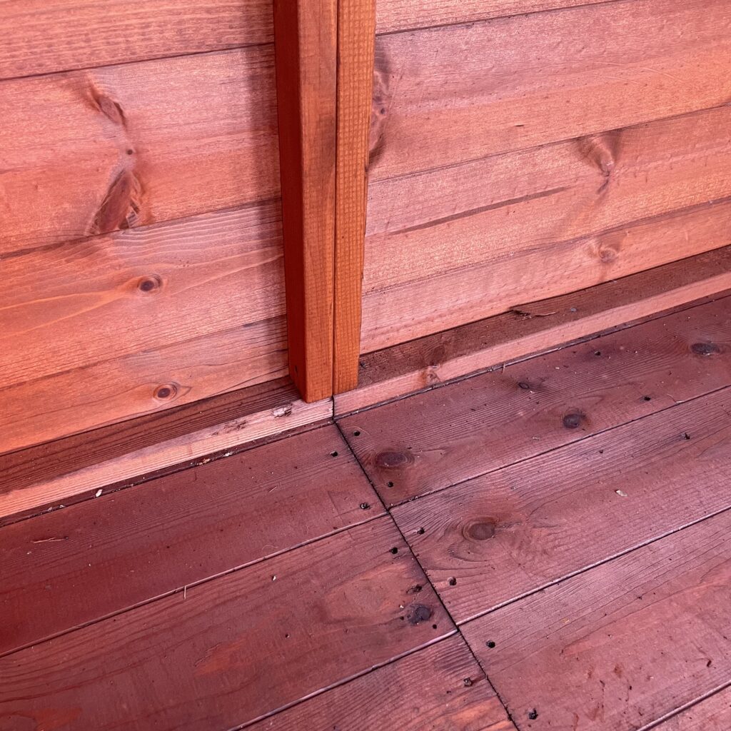 Interior view of a summerhouse corner showcasing wall and floor joinery